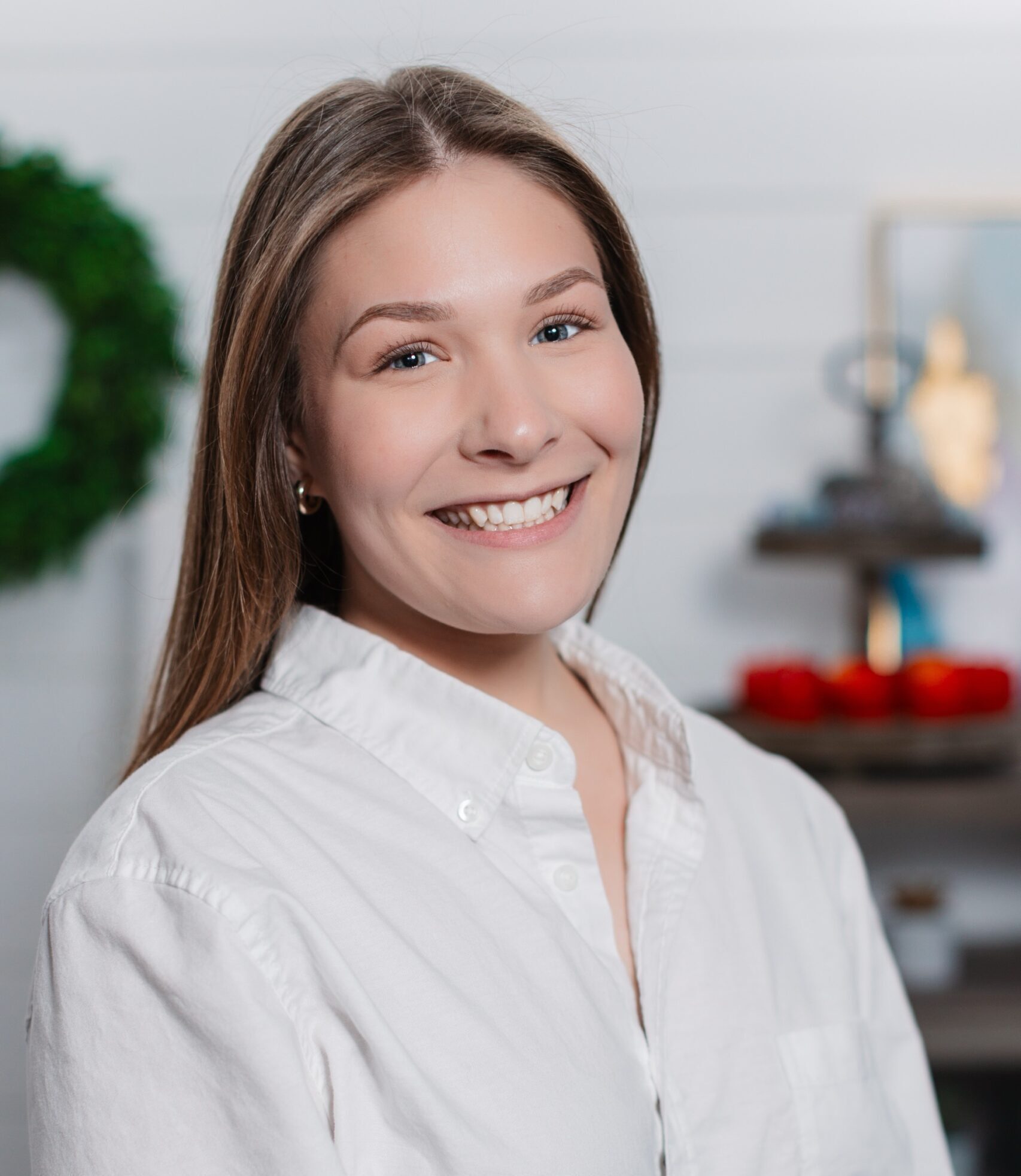 Smiling young woman in white shirt with festive background.