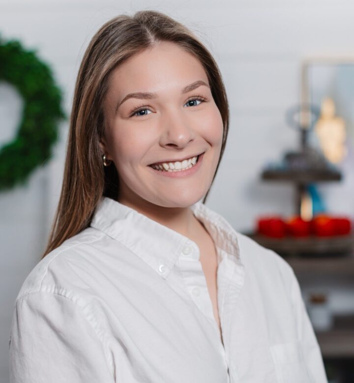 Smiling young woman in white shirt with festive background.