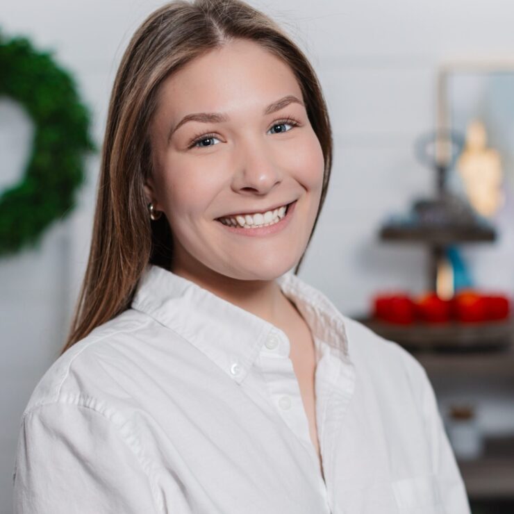 Smiling young woman in white shirt with festive background.